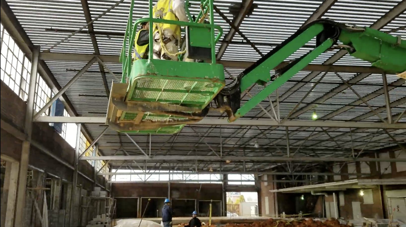 Black Card crew coating an exposed metal roof deck from an aerial lift